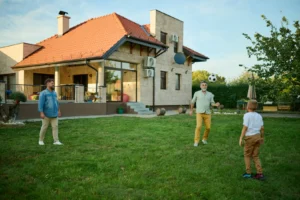 rodzina gra w piłkę na tle zaizolowanego domu